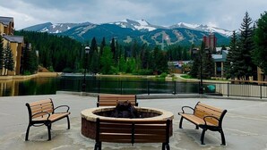 A fire pit with benches in a park with a view of mountains.