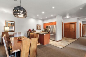 Modern kitchen with central island, stainless steel appliances, and large window.