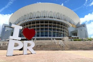 A modern building with a large circular auditorium and a prominent 'I ♥ PR' sign in front.