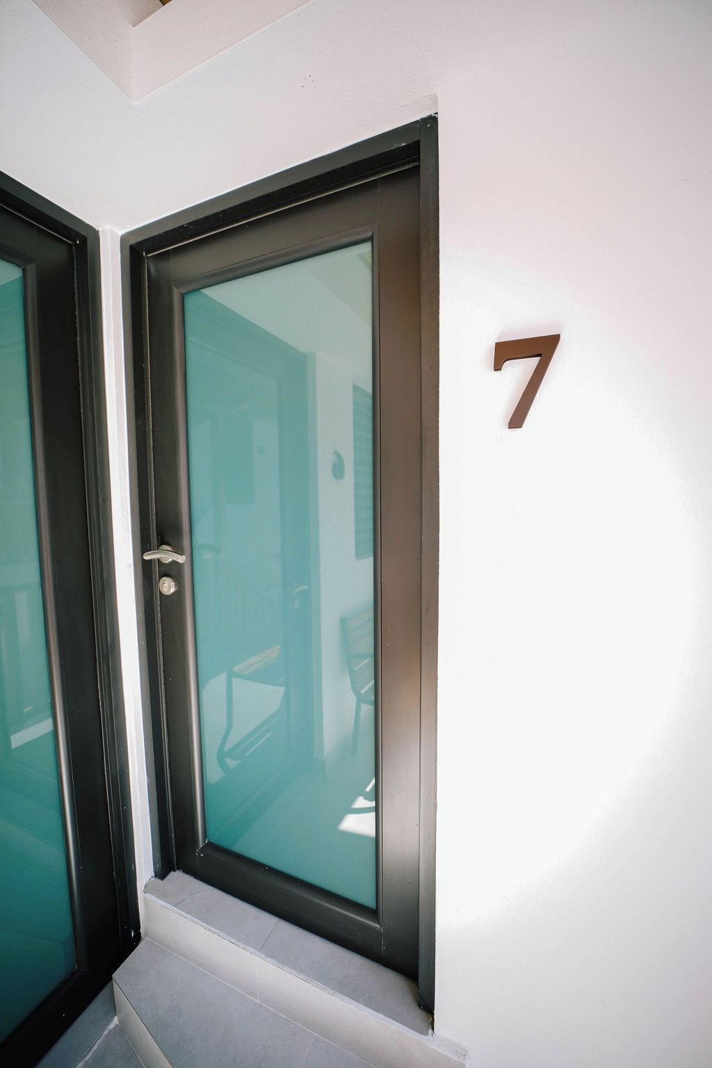 A door with a glass panel and a number '7' indicating the room number.