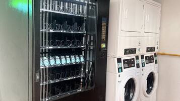 Una máquina expendedora con varios dispensadores de bebidas y una lavadora automática.