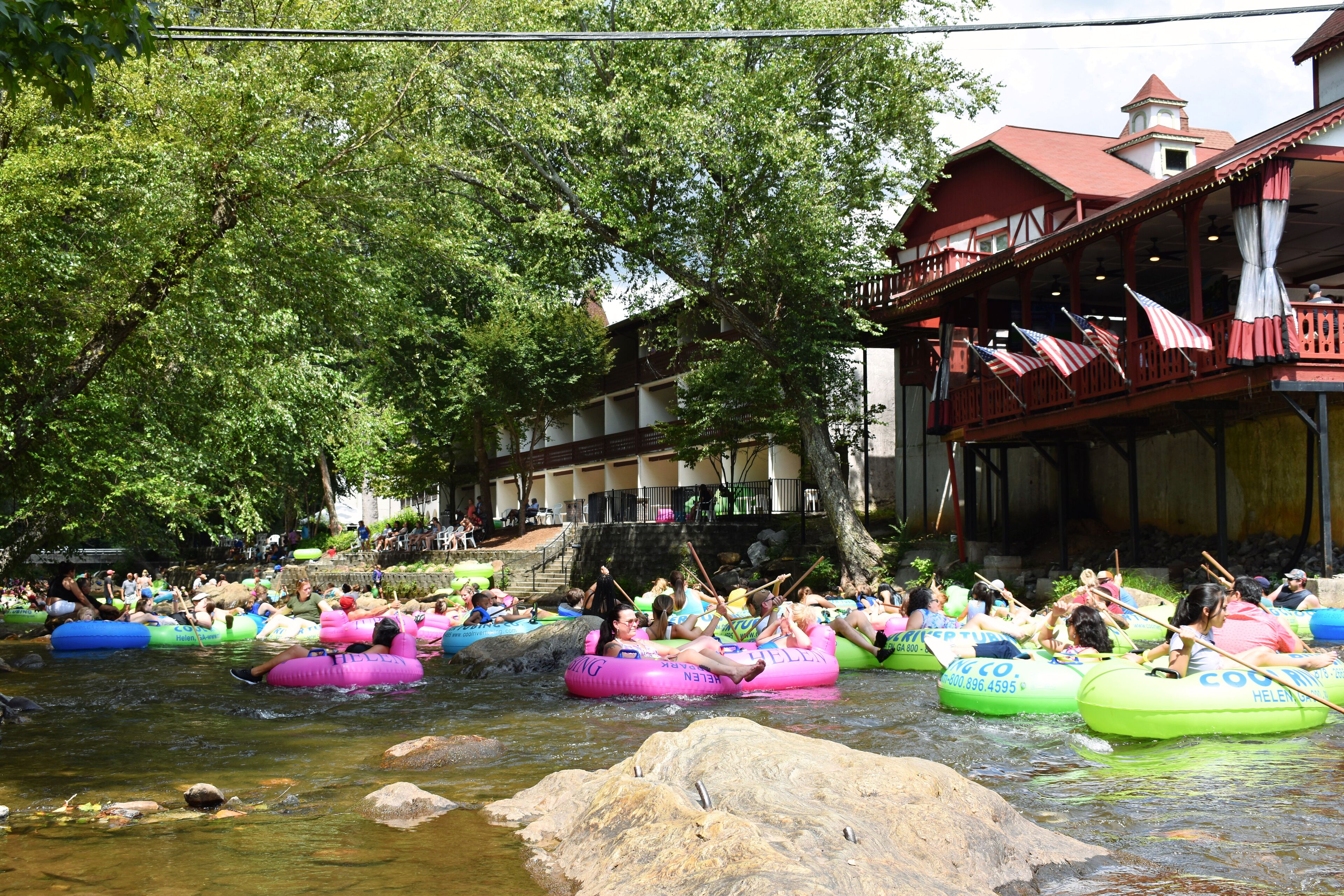 A river with people in colorful inflatable rafts.