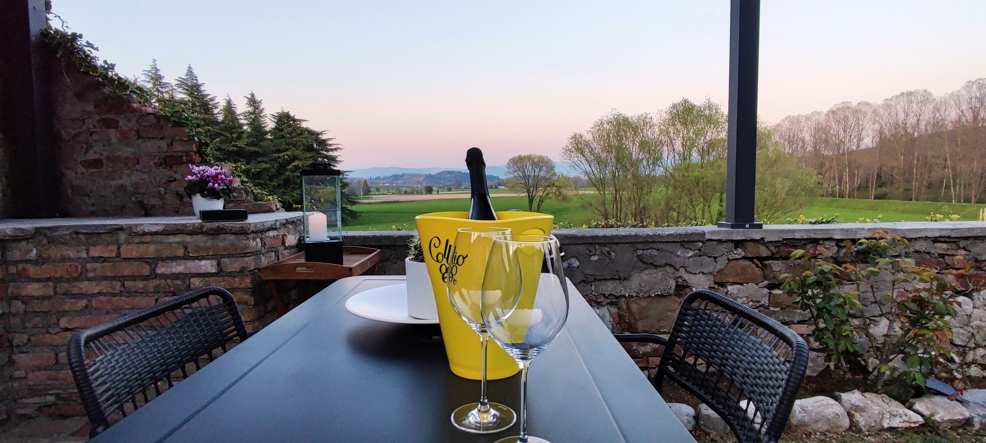 A table set outdoors with a view of a rural landscape.