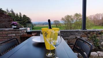 A table set outdoors with a view of a rural landscape.