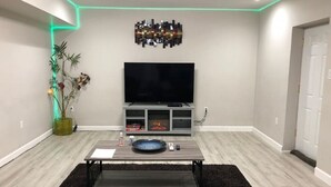 A modern living room with a flat-screen TV, a coffee table, and a seating area. - Spacious Unit with Mountain View on Route 11 (New Market)