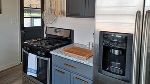 A modern kitchen with a stainless steel refrigerator, a built-in oven, and a gas stove. - Urban Ranch, at the Treasure House .. 8 bed 3 bath 2 kitchen + basement suite (Smyrna)