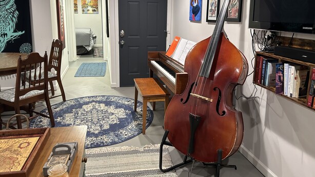 A living room with a grand piano, a cello, a bookshelf, and a television. - Urban Ranch, at the Treasure House .. 8 bed 3 bath 2 kitchen + basement suite (Smyrna)