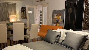 A neatly arranged bedroom with a bed, a desk, and a chair. - Yellow House (Oeiras)