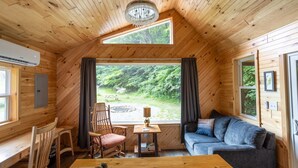 Een gezellig chaletinterieur met houten wanden, een bank, een tafel en een stoel.