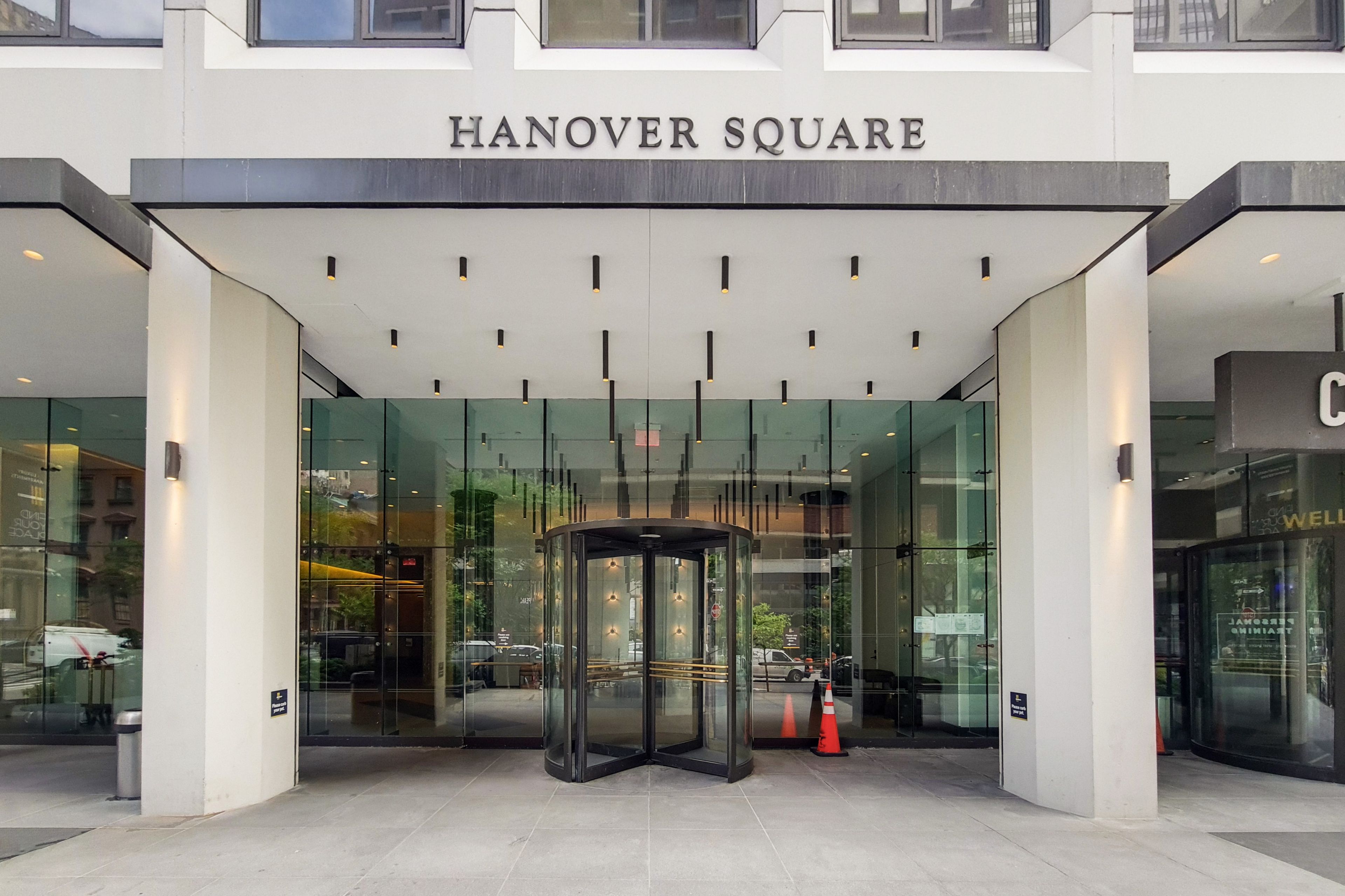La entrada de Hanover Square, con una puerta giratoria y puertas de cristal.