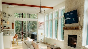 Un salón amplio con chimenea, ventanas grandes y una zona de estar acogedora.