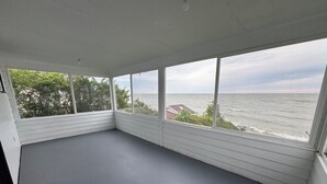 A room with a large window overlooking the sea, a grey floor, and white walls. - The Ours at Geneva on the Lake (Geneva)