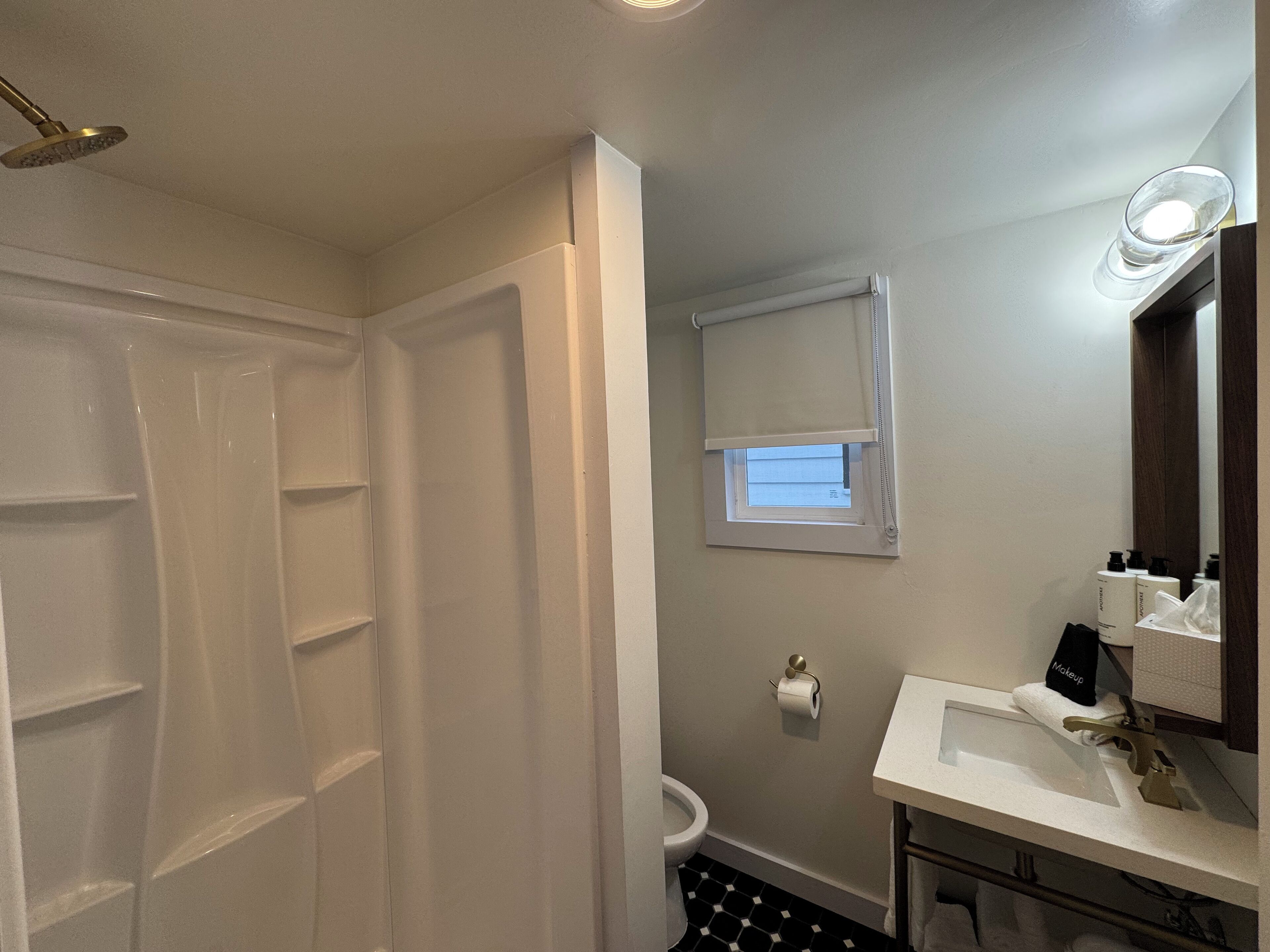 Un baño con ducha, inodoro y lavamanos.