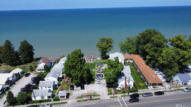 A coastal residential area with houses, a parking lot, and a view of the sea. - The Ours at Geneva on the Lake (Geneva)