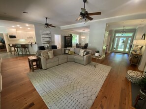 Relax in this inviting living area with a large L-shaped sofa, patterned rug, and a side table with a potted plant.