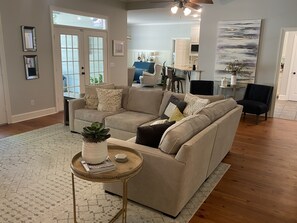 Relax in this inviting living space with a comfortable sofa, coffee table, and large window offering a view of the outdoors.