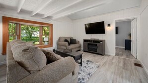 Una sala de estar moderna con un sofá modular, un televisor de pantalla plana y una chimenea.