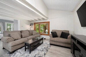 A modern living room with two sofas, a coffee table, and a TV stand. - The Brew Bungalow-Oneida Lakeside Getaway (Verona) (Canastota)