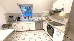 Una cocina compacta con ventana, microondas, tostadora y cafetera.