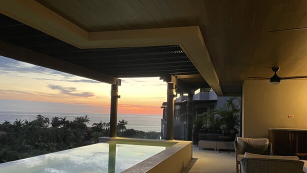 A modern outdoor seating area with a view of the ocean at sunset. - Condo Azul :Ocean View • Private Pool • Premier Access • Golf Cart • Housekeeper (Punta de Mita)