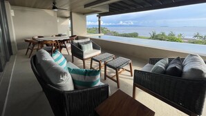 A covered outdoor seating area with wicker furniture, a dining table, and a ceiling fan. - Condo Azul :Ocean View • Private Pool • Premier Access • Golf Cart • Housekeeper (Punta de Mita)