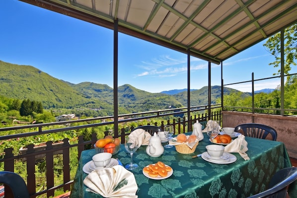 Une table dressée pour le petit-déjeuner, avec une vue imprenable sur les montagnes.