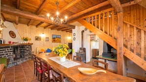 A wooden interior with a dining table, chairs, a chandelier, a fireplace, and a staircase. - Casa Busso, Esino Lario, Italy (Esino Lario)