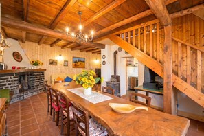 A wooden interior with a dining table, chairs, a chandelier, a fireplace, and a staircase. - Casa Busso, Esino Lario, Italy (Esino Lario)