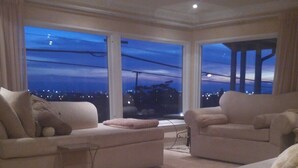 A spacious living room with two large sofas and a coffee table, large windows with a city view, and a modern ceiling design. - Shared Home (Inglewood)