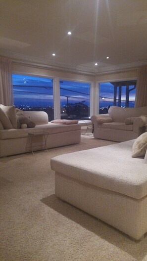 A spacious living room with two large sofas and a coffee table, large windows with a city view, and a modern ceiling design. - Shared Home (Inglewood)
