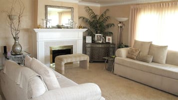 A living room with a fireplace, a sofa, a coffee table, and a lamp.