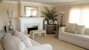 A living room with a fireplace, a sofa, a coffee table, and a potted plant. - Shared Home (Inglewood)