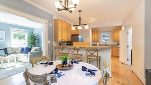 A dining area with a round table, wooden chairs, and a chandelier. - USNA Home Steps to Stadium Dog-Friendly w Parking (Annapolis)