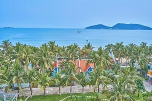 A coastal view with palm trees, a beach, and a distant mountain range. - Haidu Hotel (Taishan)