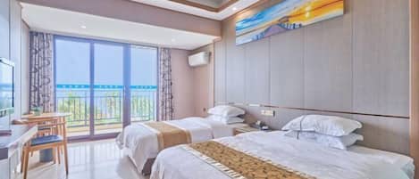 Habitación de hotel con dos camas, un escritorio y un ventanal con vistas.