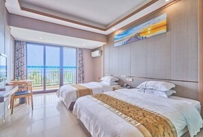 A hotel room with two beds, a desk, and a large window with a view. - Haidu Hotel (Taishan)