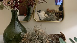 A room with a green vase, a woven basket, and a small potted plant on a wooden table. -  Beautiful charming flat, beautiful terrace facing the sea. Exceptional location (Albufeira)