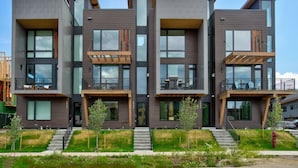 A modern multi-story residential building with balconies, large windows, and a flat roof. - Urban Luxury - Rooftop Patio w/ Hot Tub, Perfect for 2 Families at Competitive Rates (Steamboat Springs)