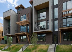 A modern multi-story building with balconies and large windows.