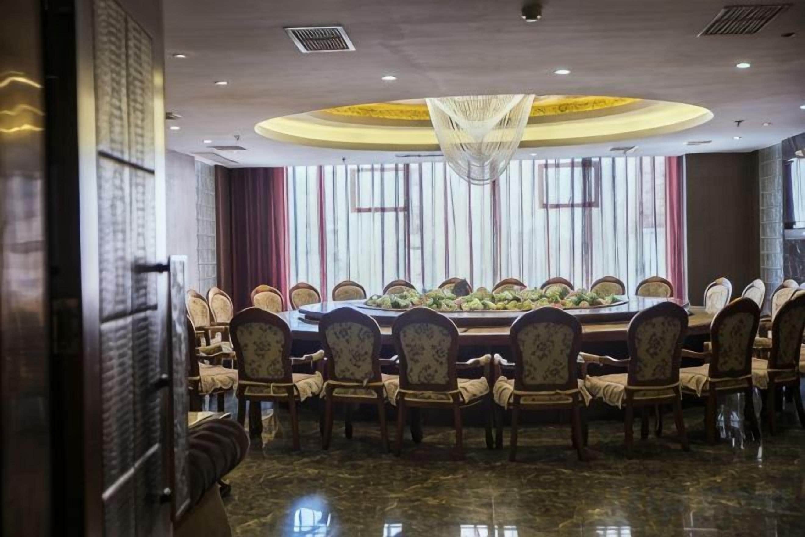 A conference room with a large oval table, multiple chairs, and a chandelier.