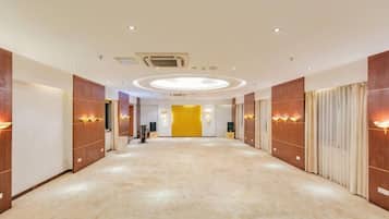 A hotel corridor with a carpeted floor, wooden panel walls, and recessed lighting.