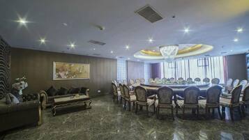 A conference room with a round table, chairs, and a chandelier.