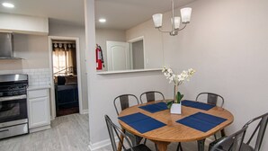 A compact kitchen with a stove, oven, and a dining area with a round table and chairs.