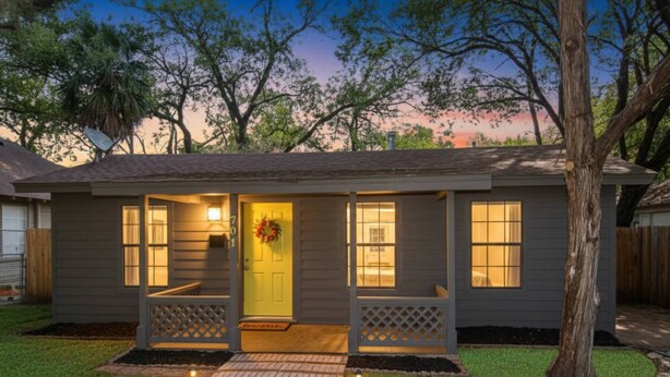 A single-story house with a front porch, a door with a wreath, and a number '701' on the door.