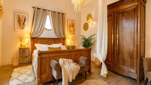 Un dormitorio con cama de madera, lámparas de noche, un armario grande y un aplique colgante.