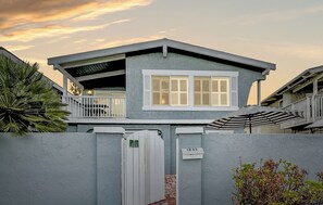 A two-story house with a balcony, a gated entrance, and a mailbox.