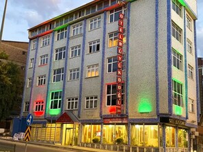 A multi-story hotel with a prominent vertical sign displaying its name. - Otel Büyük Doğu  (Erzurum)