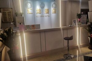 A hotel reception desk with a modern design, featuring a reception counter and a seating area.