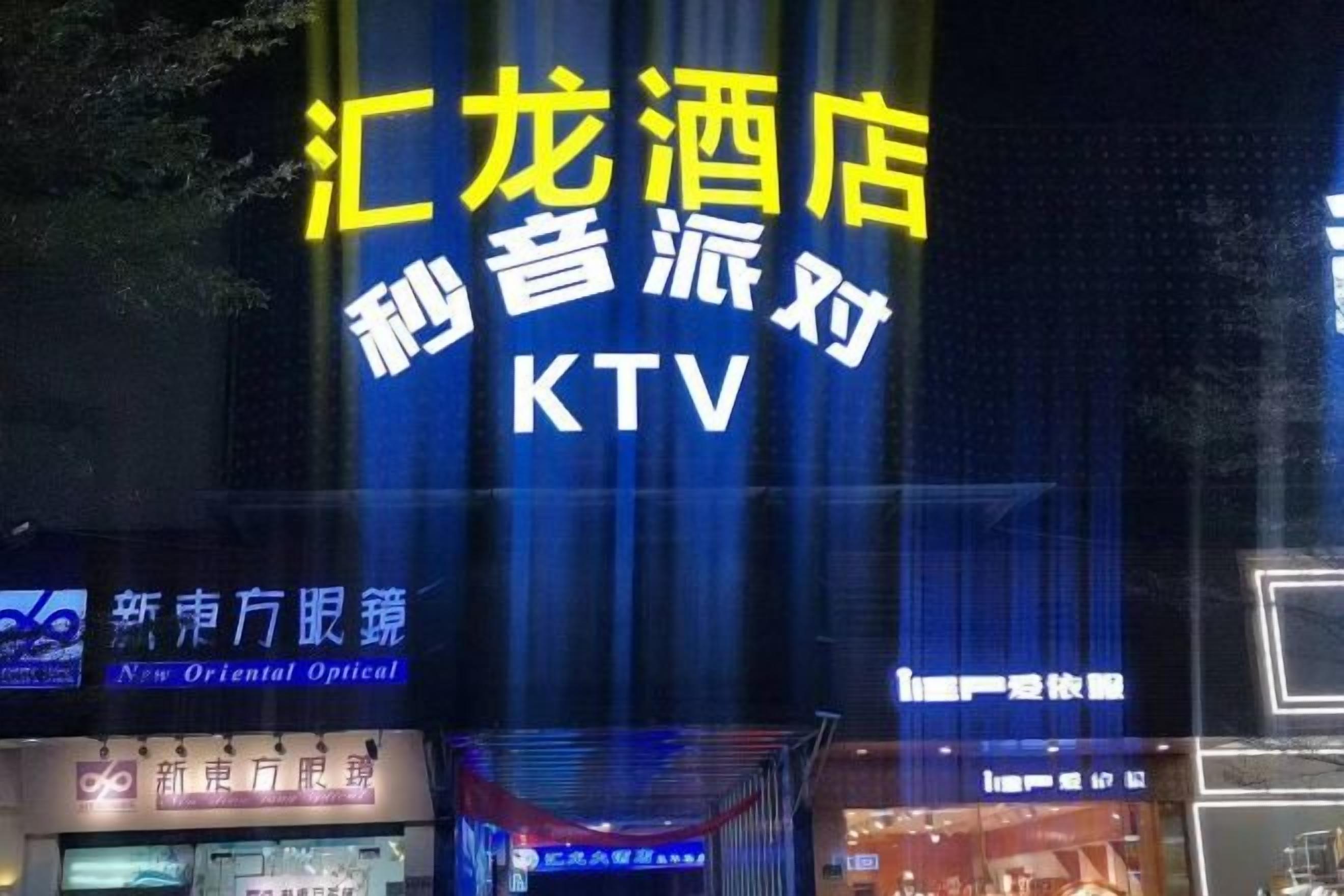 A hotel sign with the name 'KTV' and a neon sign above it.