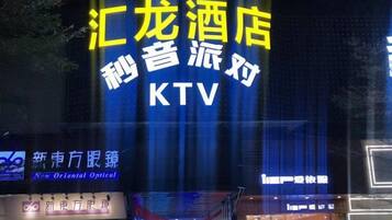 A hotel sign with the name 'KTV' and a neon sign above it.